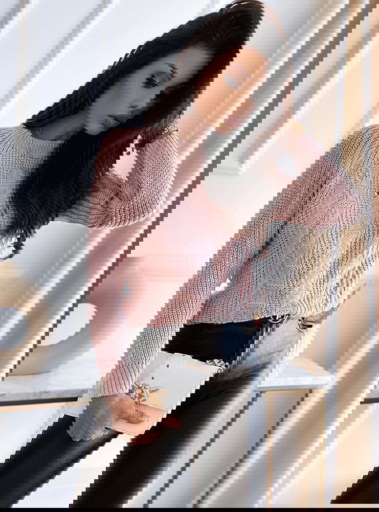 Pudrowy sweterek z ozdobnymi splotami...