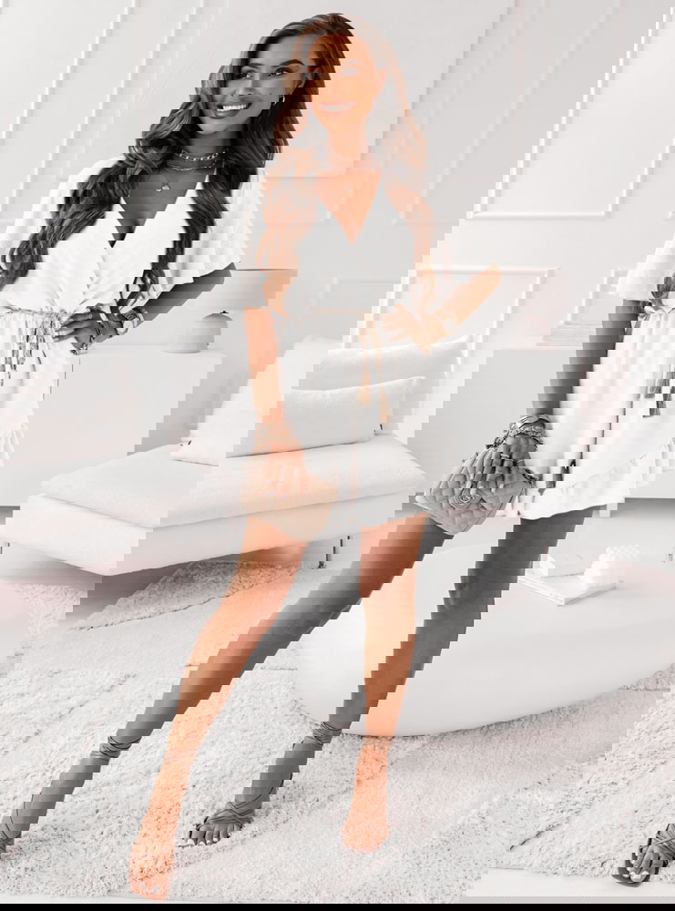 Biały kombinezon z ozdobnym paskiem...