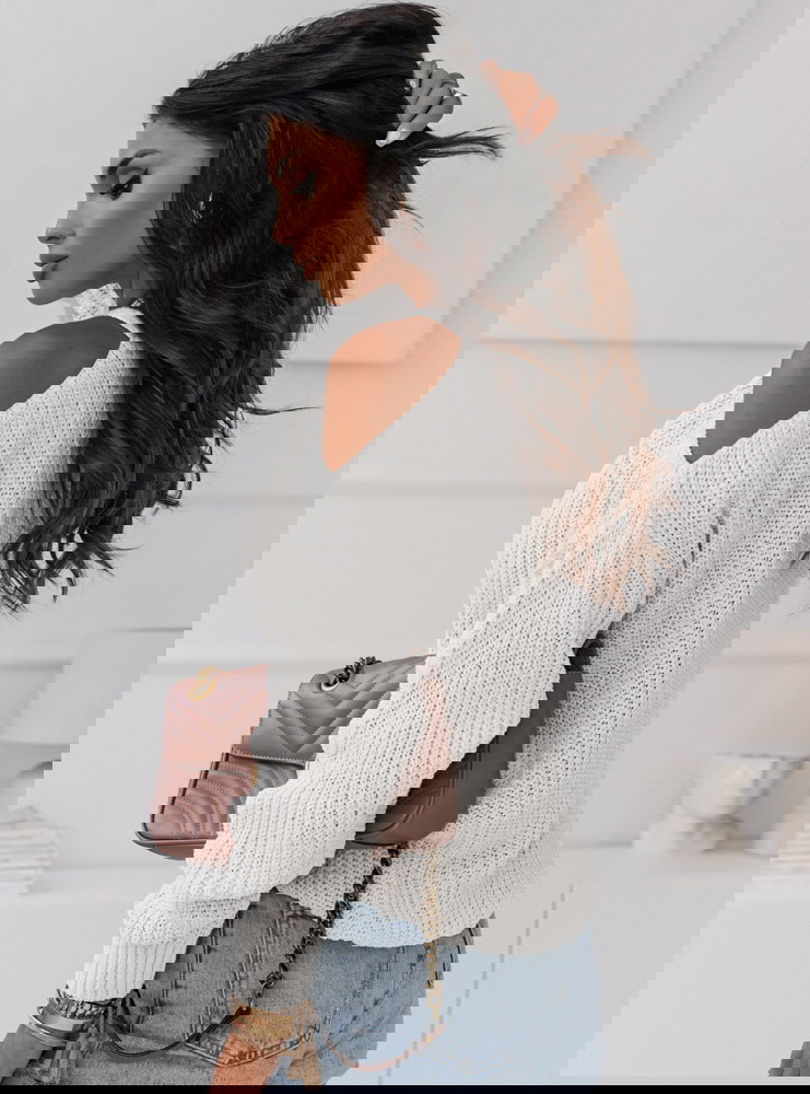 Biały sweter z odkrytym ramieniem...