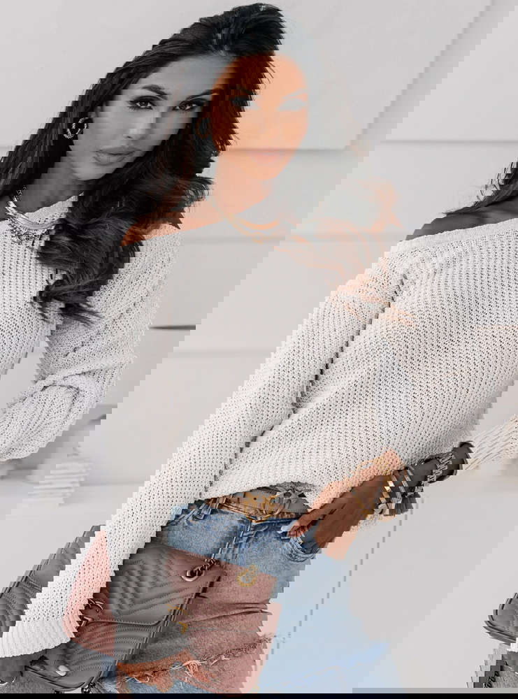 Biały sweter z odkrytym ramieniem...