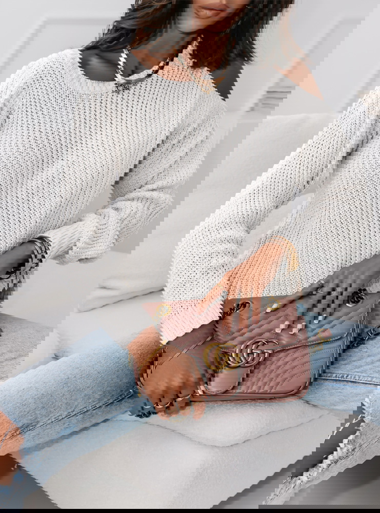 Biały sweter z odkrytym ramieniem...