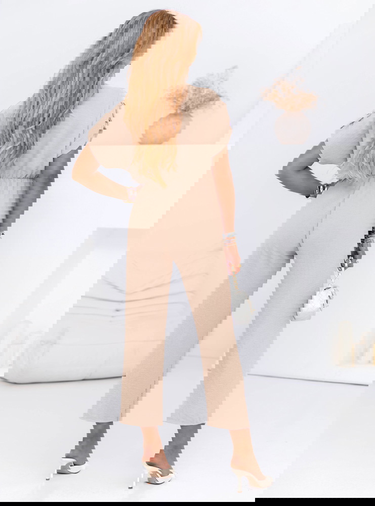 Beżowy kombinezon z guzikami na...