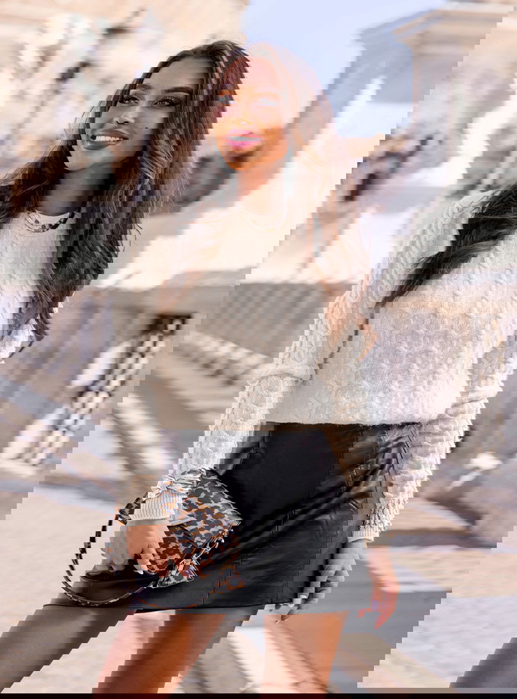 Beżowy sweter z warkoczowymi splotami...