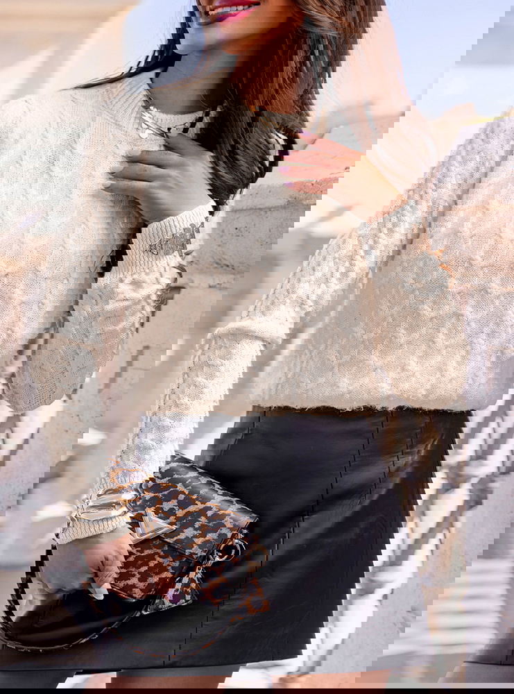 Beżowy sweter z warkoczowymi splotami...