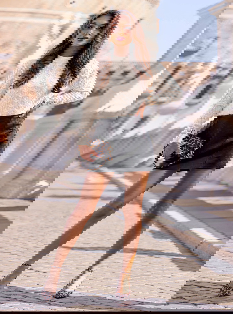 Beżowy sweter z warkoczowymi splotami...