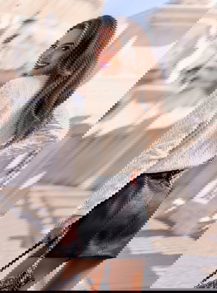 Beżowy sweter z warkoczowymi splotami...