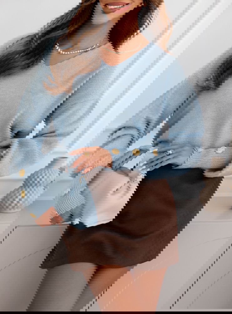 Błękitny sweter z ozdobnymi guzikami...