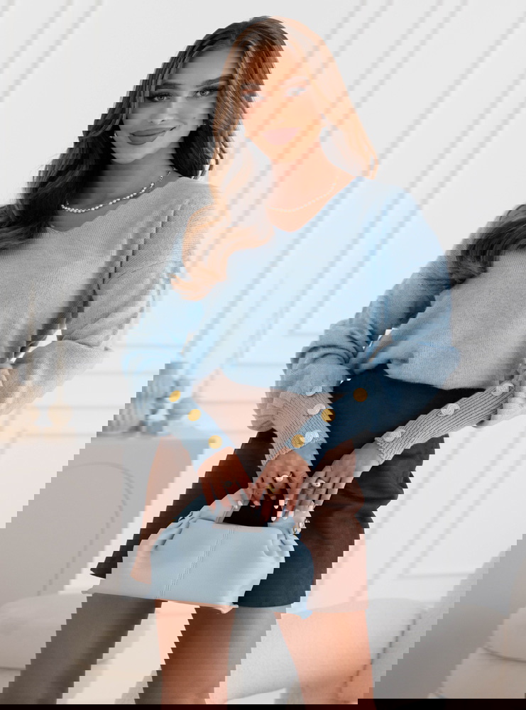 Błękitny sweter z ozdobnymi guzikami...