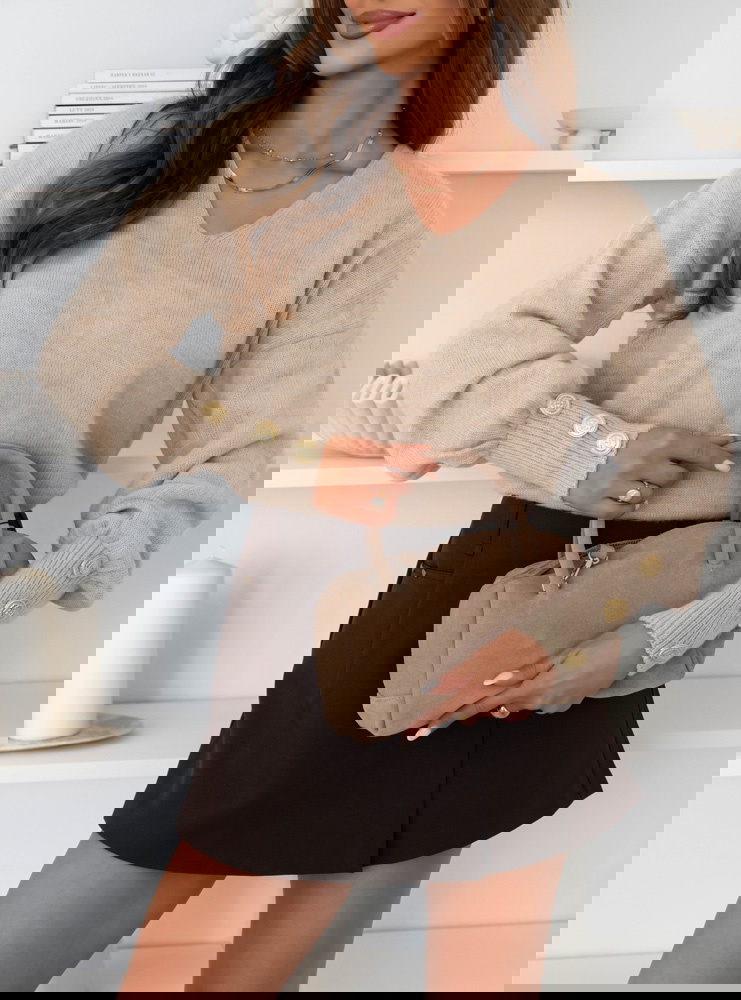 Beżowy sweter z ozdobnymi guzikami na...