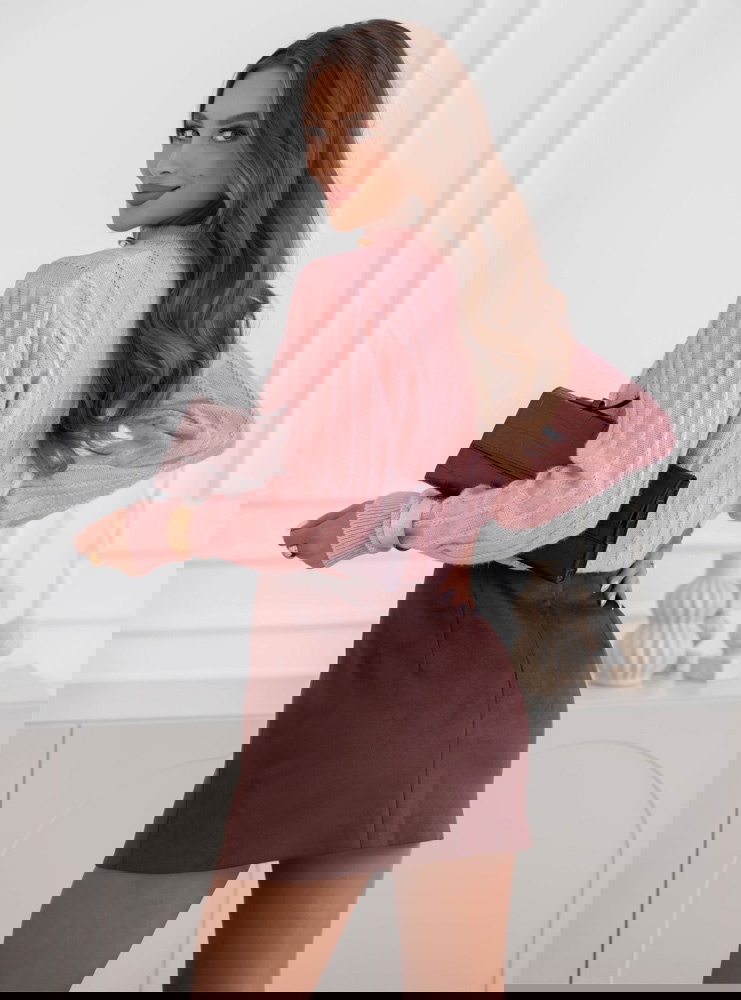 Pudrowy sweter zapinany na guziki...