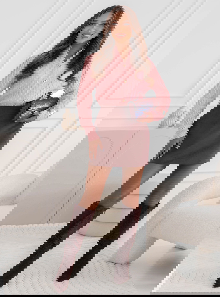 Pudrowy sweter zapinany na guziki...