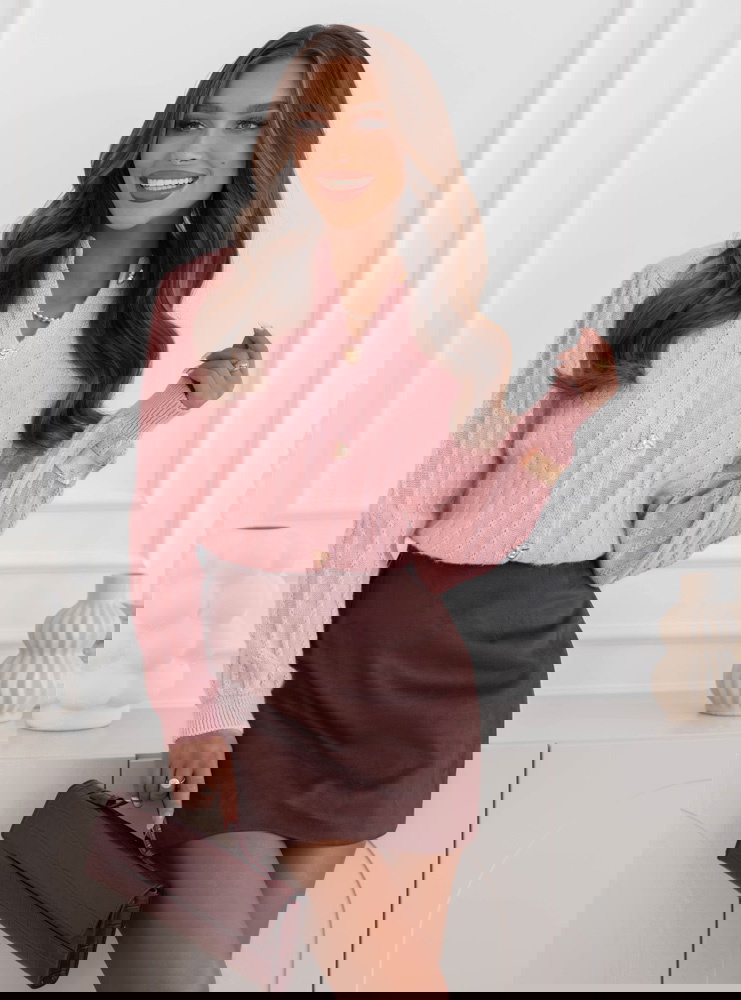 Pudrowy sweter zapinany na guziki...