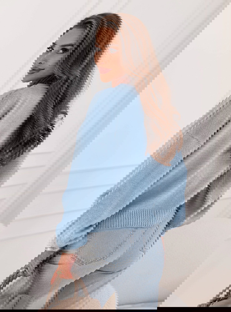 Błękitny sweter zapinany na guziki...