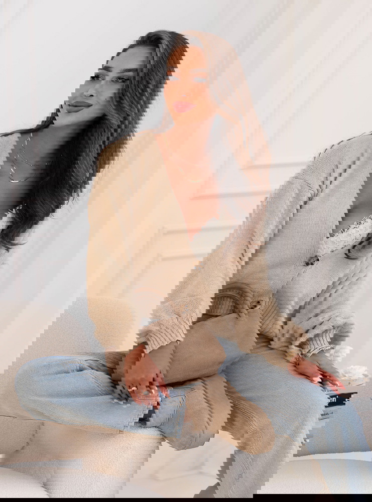 Beżowy sweter zapinany na guziki...