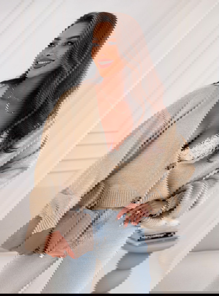 Beżowy sweter zapinany na guziki...