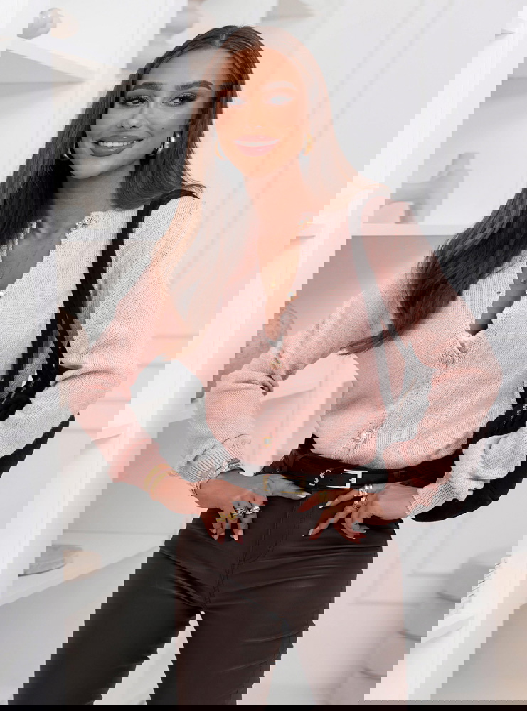 Pudrowy sweter zapinany na guziki...