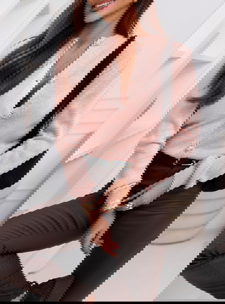 Pudrowy sweter zapinany na guziki...