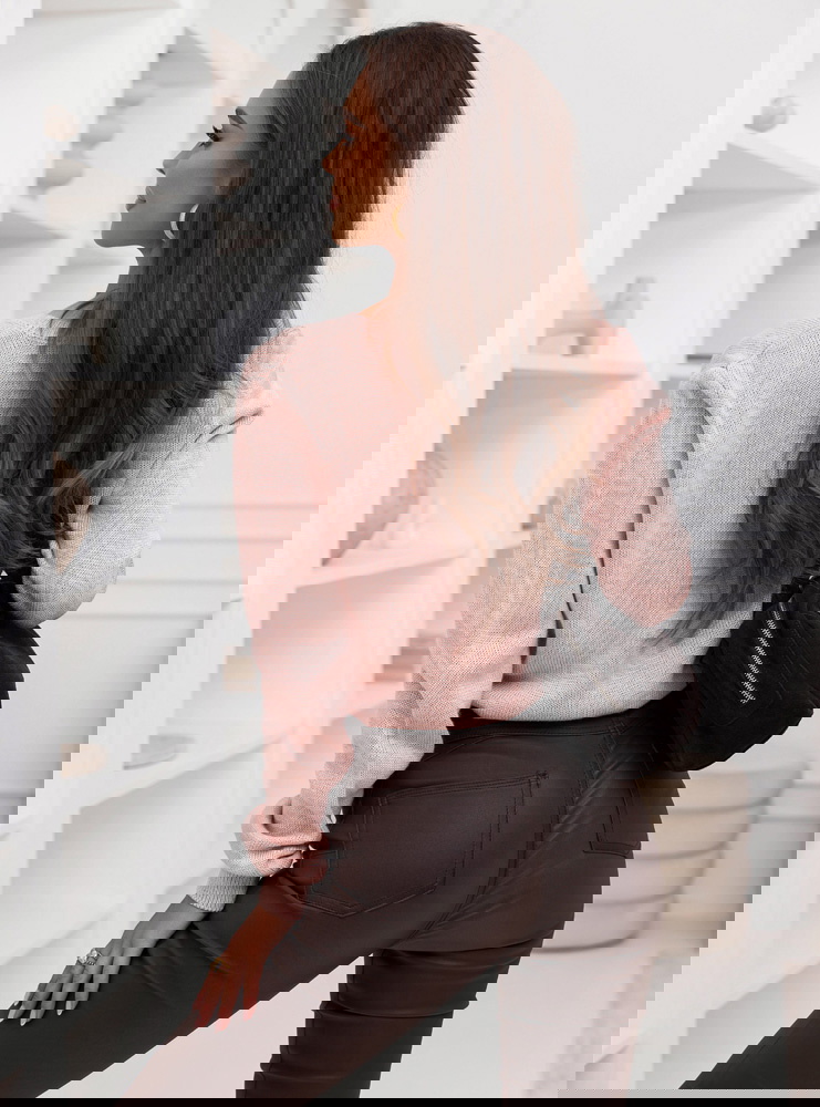 Pudrowy sweter zapinany na guziki...