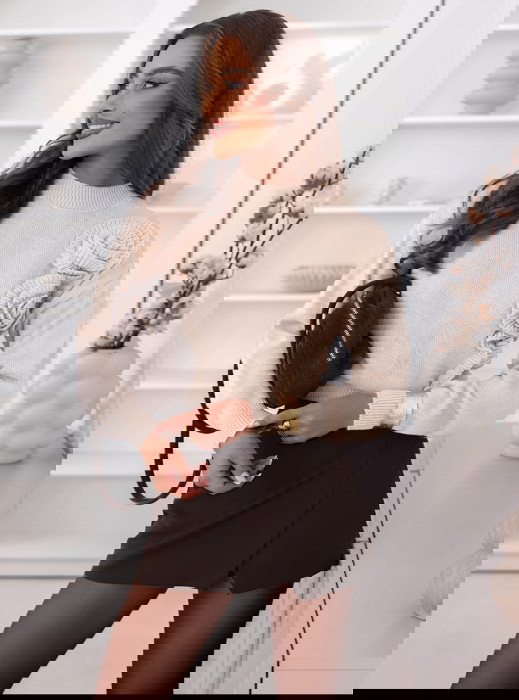 Beżowy sweter z ozdobnymi kwiatami...