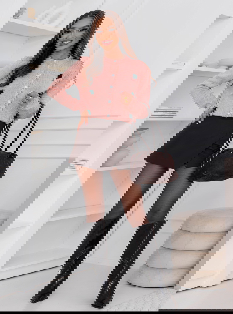 Pudrowy sweter zapinany na guziki...