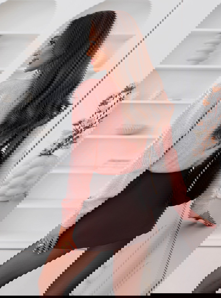 Pudrowy sweter zapinany na guziki...