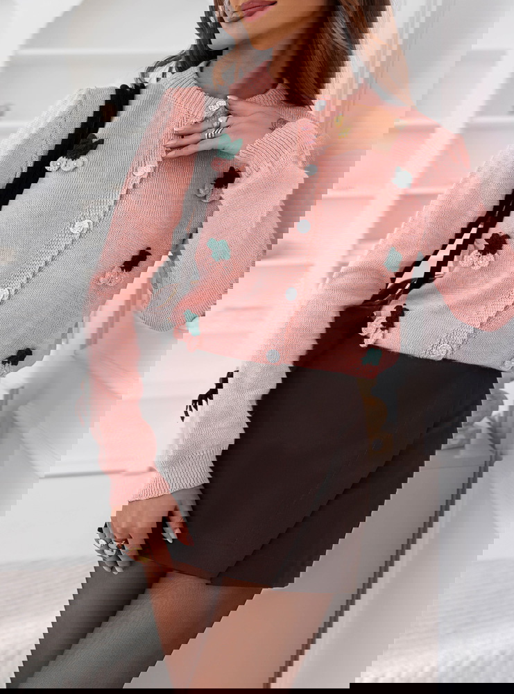 Pudrowy sweter zapinany na guziki...