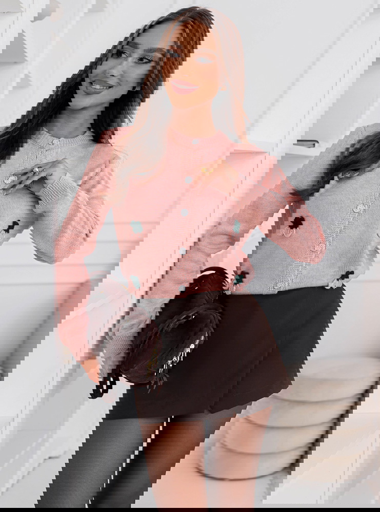 Pudrowy sweter zapinany na guziki...