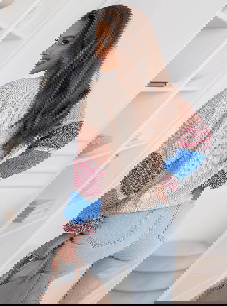 Beżowy sweter z ozdobnymi rękawami...