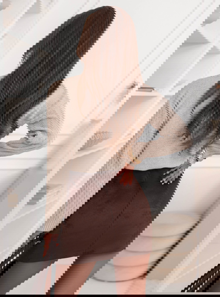 Beżowy sweter z warkoczowymi splotami...