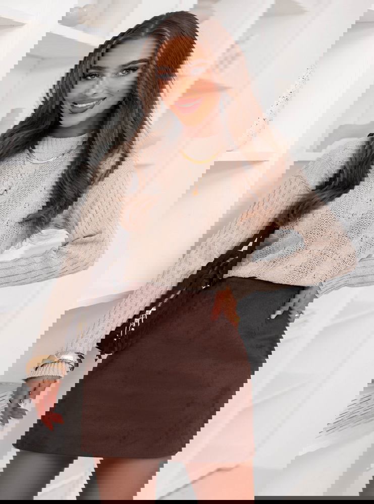 Beżowy sweter z warkoczowymi splotami...