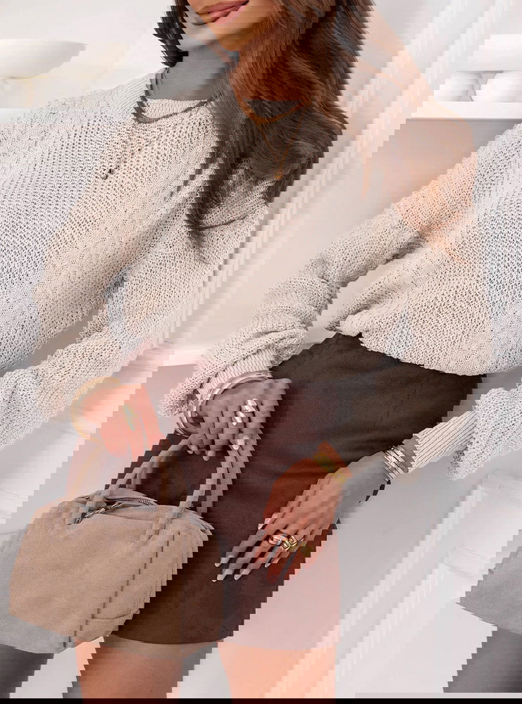 Beżowy sweter z warkoczowymi splotami...