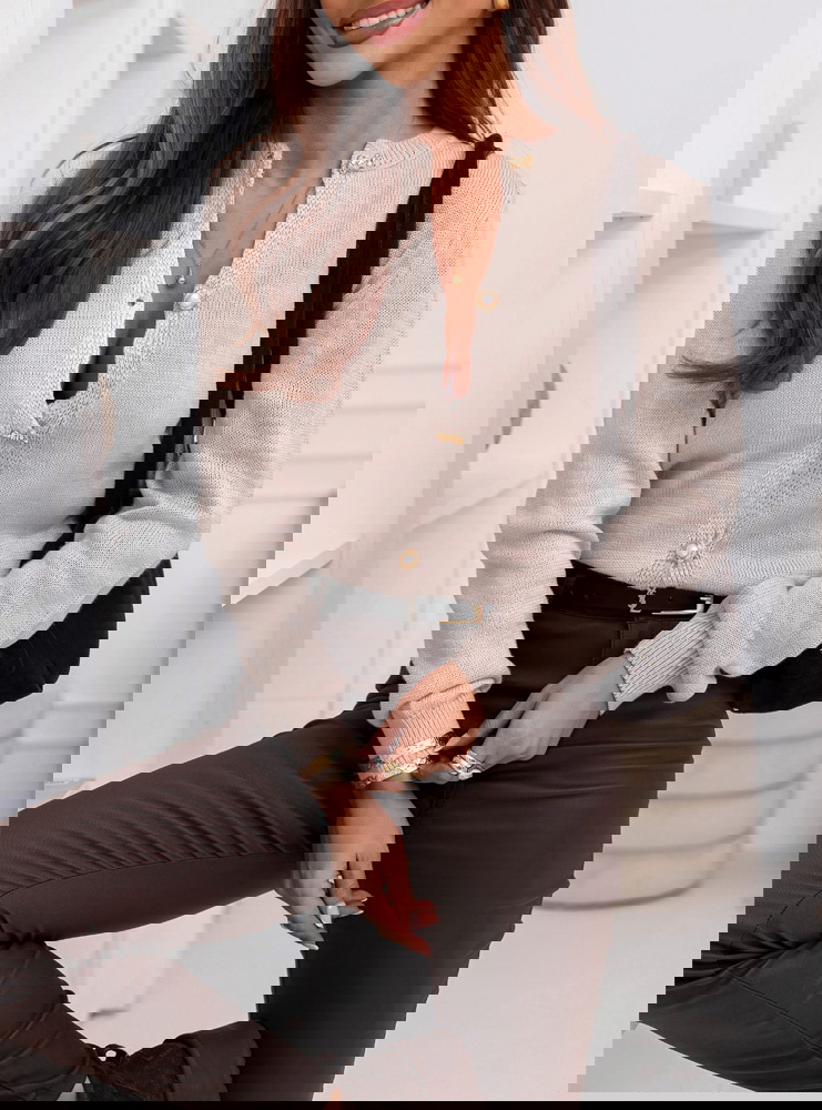 Beżowy sweter zapinany na guziki...