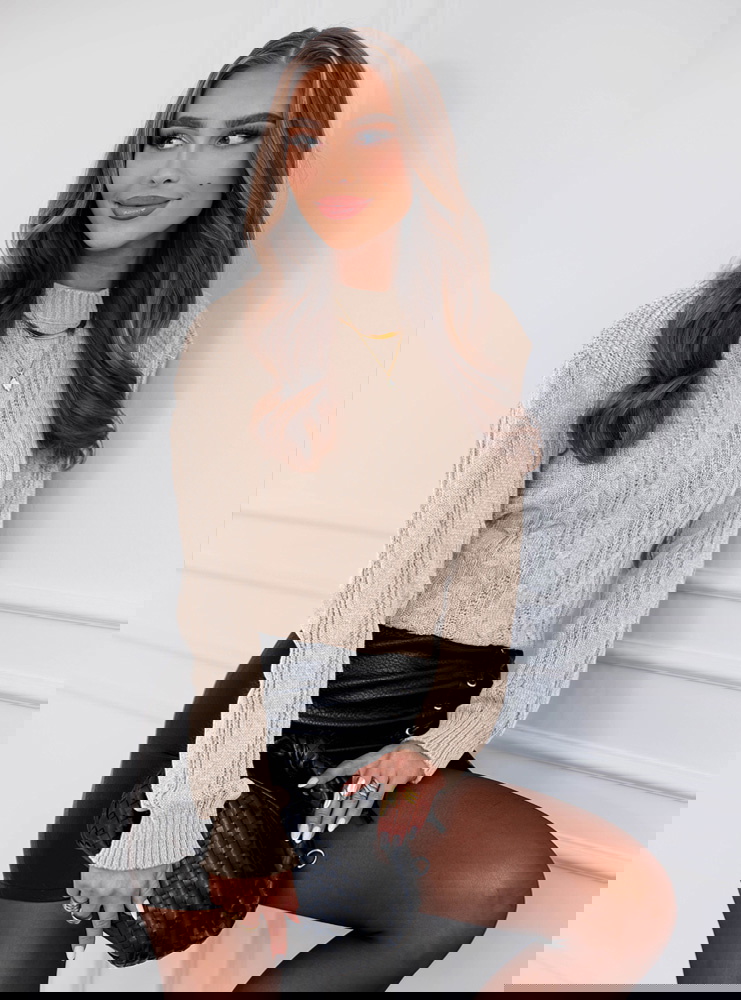 Beżowy sweter z warkoczowymi splotami...