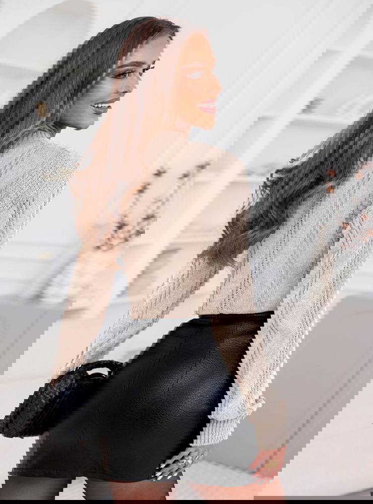 Beżowy sweter z warkoczowymi splotami...