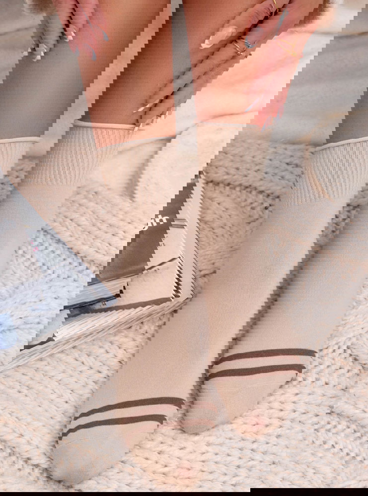 Beżowe skarpetki z ozdobną naszywką...