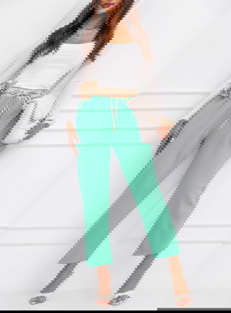 Miętowe spodnie z ozdobnym paskiem...