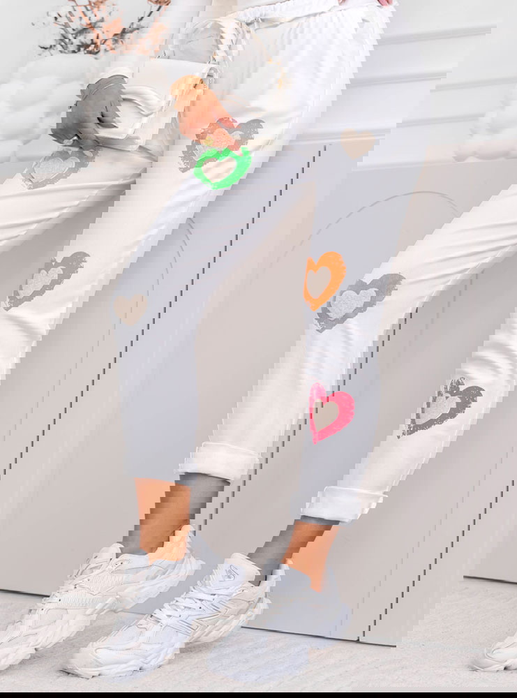 Białe spodnie z ozdobnymi naszywkami...