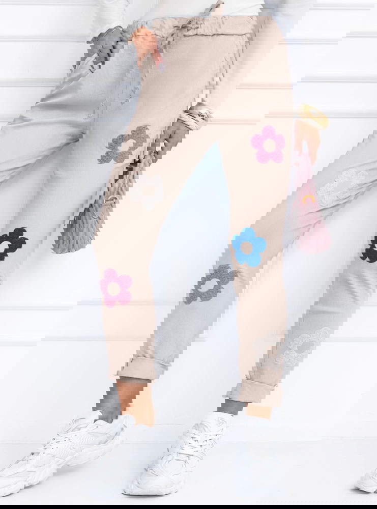 Beżowe spodnie z ozdobnymi kwiatkami...