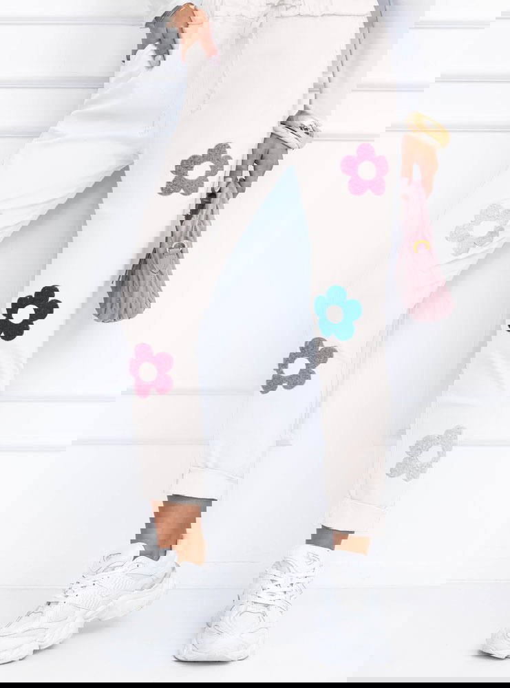 Białe spodnie z ozdobnymi kwiatkami...