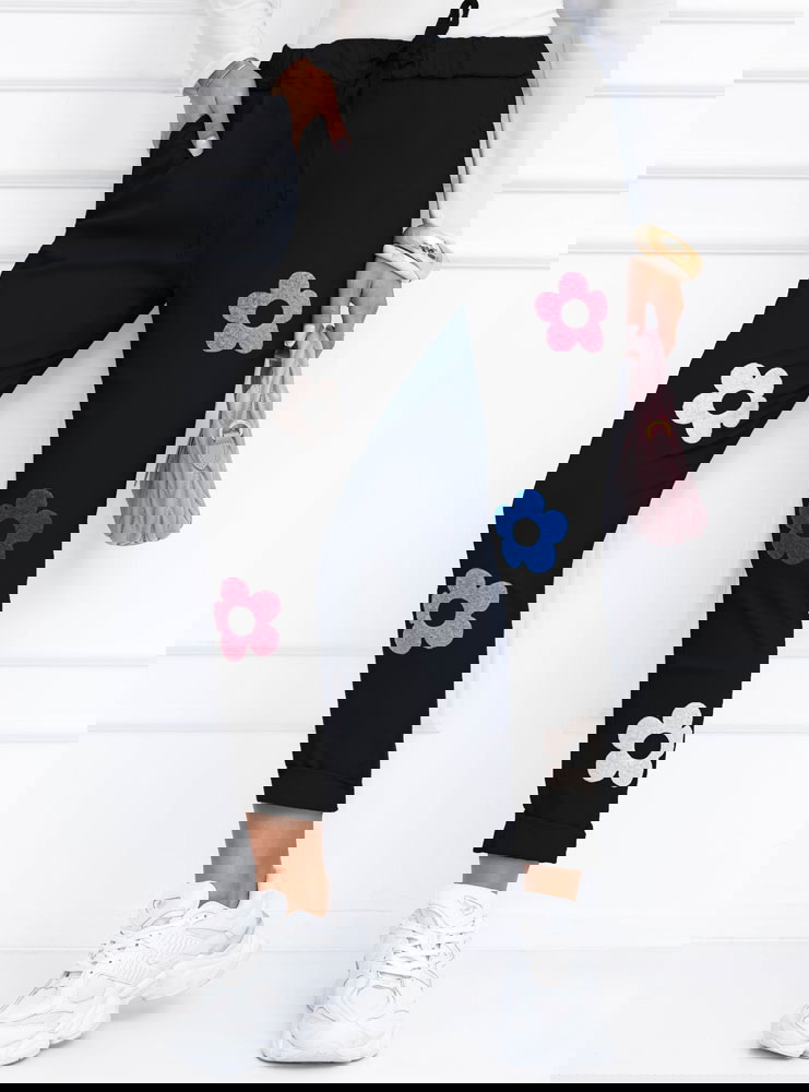 Czarne spodnie z ozdobnymi kwiatkami...